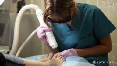 医生正在对一名妇女的脚进行激光治疗，目标是大脚趾指甲周围的皮肤